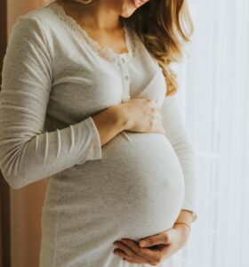 gravid kvinne som holder på magen