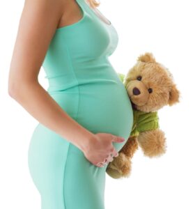 gravid kvinne som holder en teddybjørn